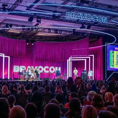 A panel on the pink-curtained Glam Stage in front of a full audience