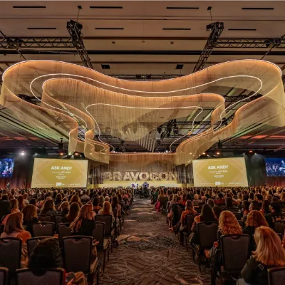 The Gold Stage hall filled with fans beneath a golden chandelier